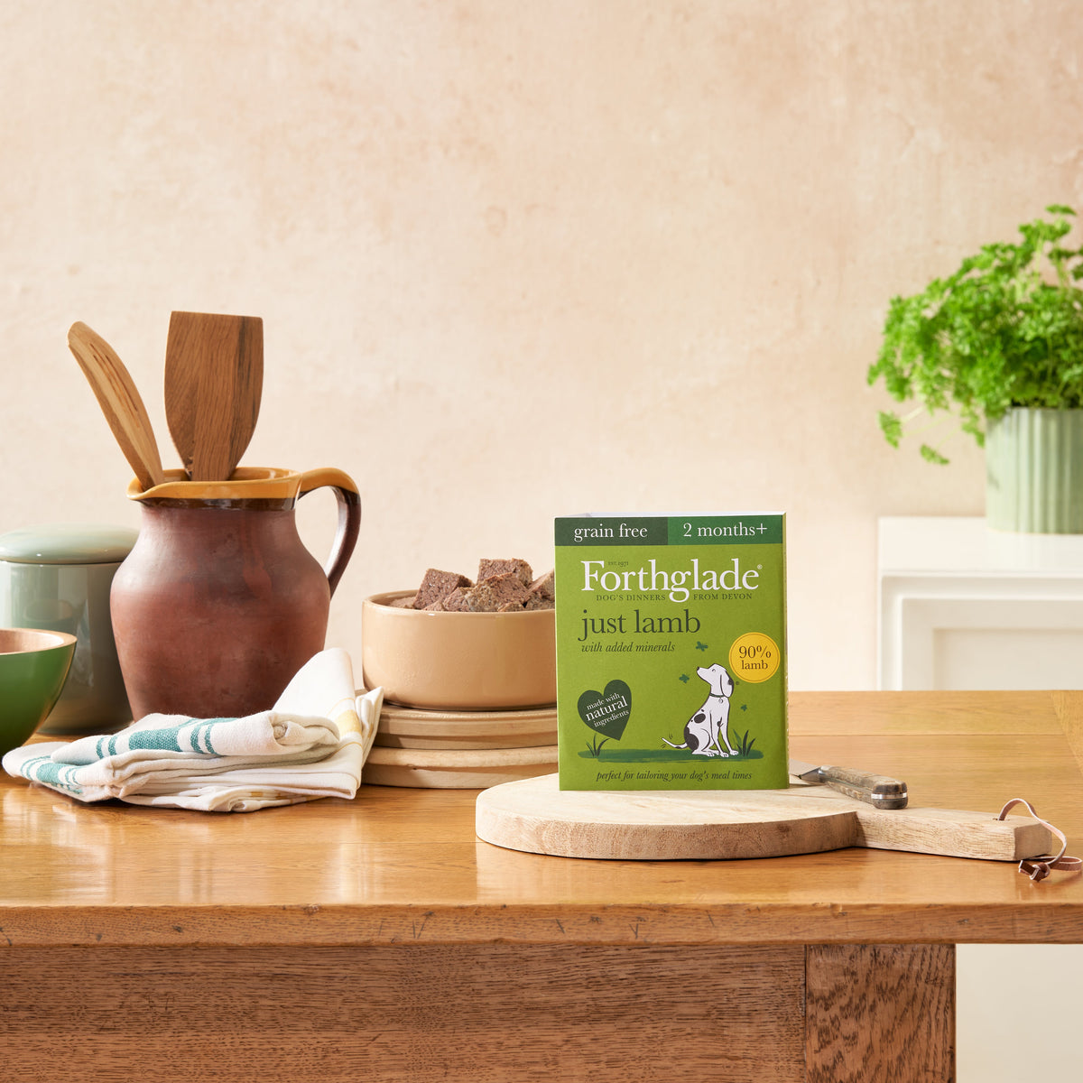 Forthglade Just Lamb tray on a wooden chopping board beside a bowl of the food