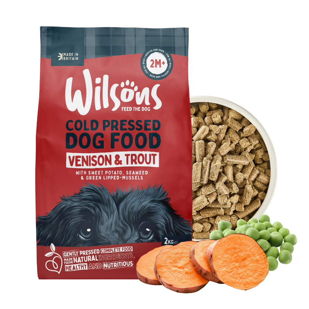 Wilsons cold pressed venison and trout dog food bag beside a bowl of the food with sweet potato and peas