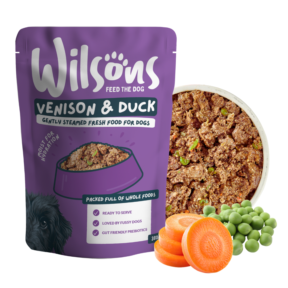 Wilsons Venison and Duck fresh pouch beside a bowl of the food with carrots and peas