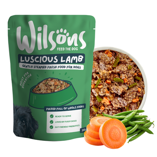 Wilsons Luscious Lamb fresh pouch beside a bowl of the food with carrots and green beans